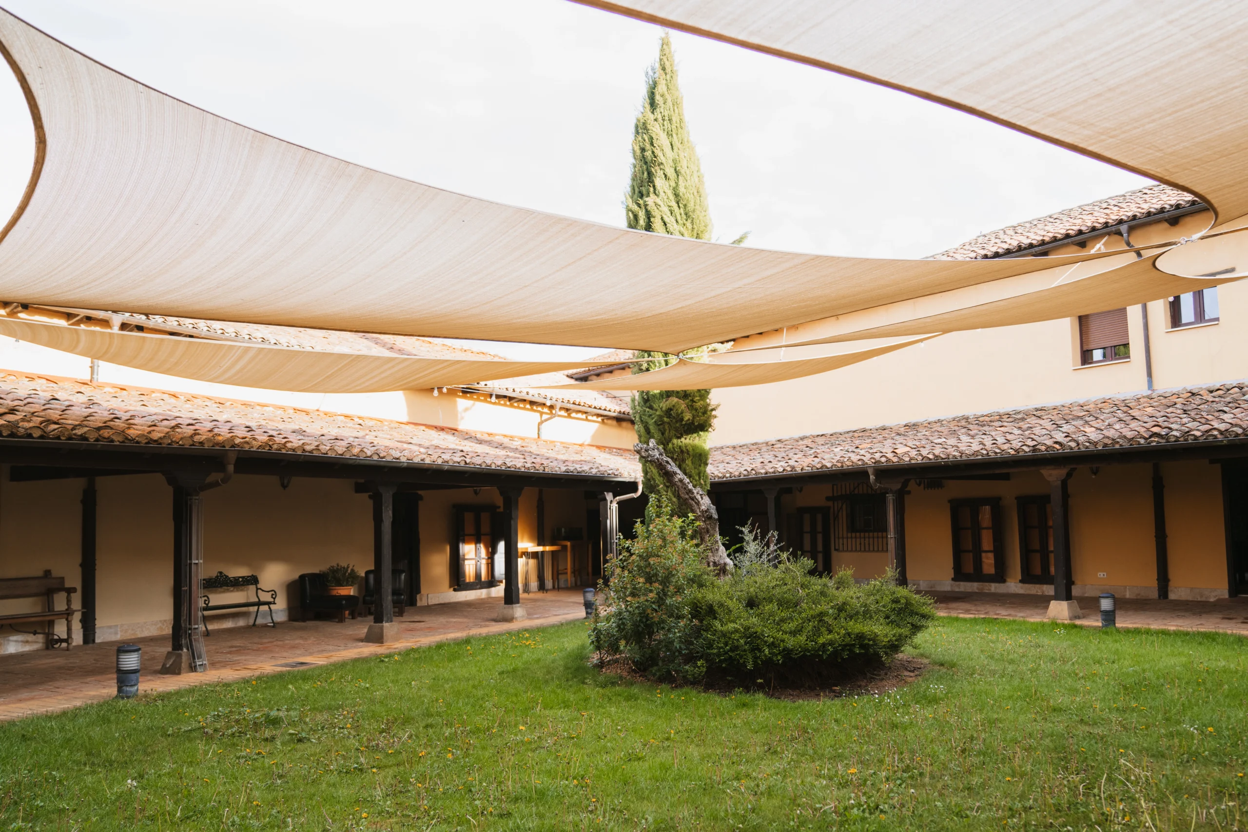 Camino hacia una carpa decorado para una evento con flores, sombrillas y lámparas